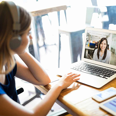 a woman wearing headphones using a laptop