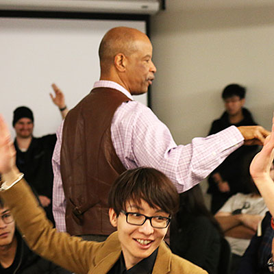 students raising hands in a small classroom