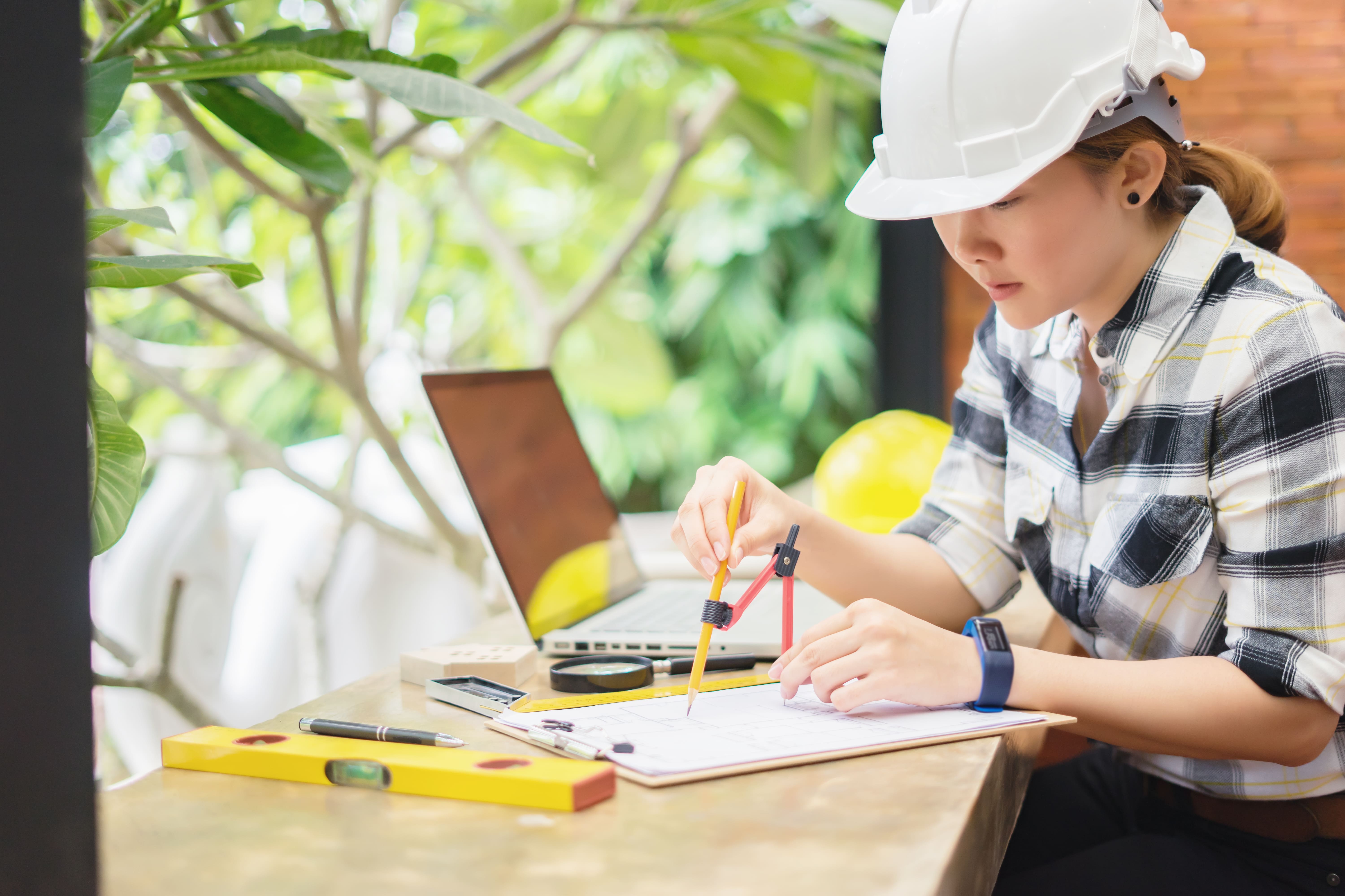 woman in hardhat working at a table